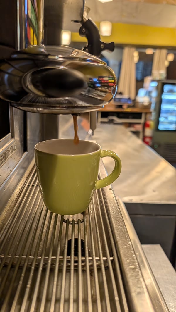 Espresso being pulled into a green mug